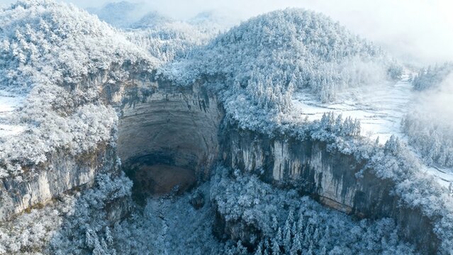 Aerial view of a snow-covered sinkhole in a forested mountain landscape - Powered by Adobe