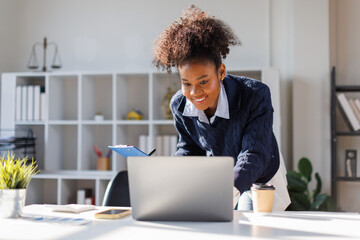 Business in afro hair discussing financial reports and marketing charts during corporate meeting, focusing on strategy, planning, data analysis, on laptop at office