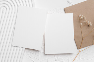 Wedding invitation card mockup with elegant design elements, featuring textured background and dried flowers, ideal for personalized event announcements and creative projects