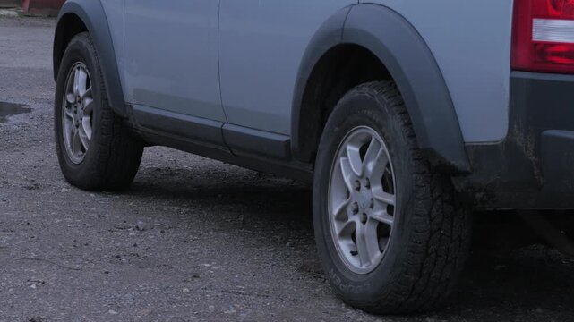 SUV close up lowering of air suspension, vehicle descends with loud whirring, grinding, mechanical sound, sync audio
