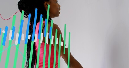 Standing woman wearing bright pink sleeveless top showing braided hair in studio, with data charts