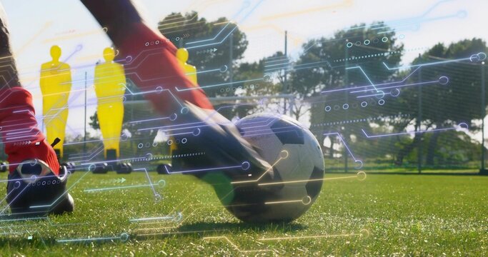 Striking player feet in red socks contacting soccer ball on turf, mannequins and overlay