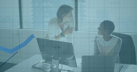 Talking, two women in workwear leaning and sitting at office desk with laptop monitor blue overlay