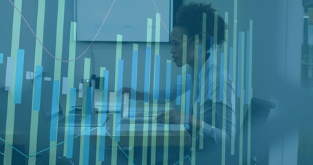 Analyzing data, woman wearing striped shirt leaning toward laptop at office with data overlay