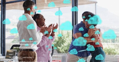 Clapping coworkers in business attire hugging and celebrating in glass office with laptop and cloud