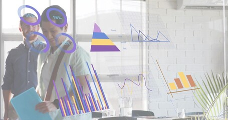 Walking three staff in shirts passing glass wall with projected charts in office holding folder