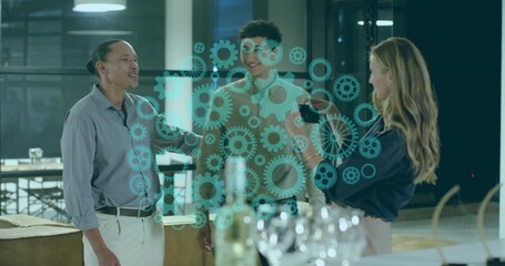 Standing trio in business attire talking in office with teal gear overlay, wine glasses and bottle