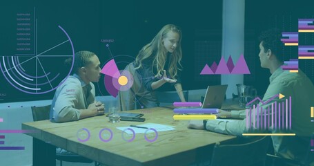 Presenting woman wearing business attire leaning over wooden table at office, with laptop charts