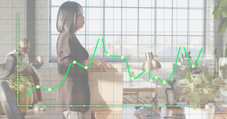 Holding moving box, Asian woman wearing blazer, trousers standing by office window with green graph