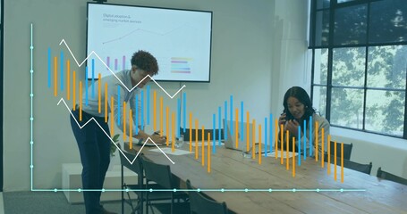 Discussing business casual colleagues preparing presentation at office table with laptop and phone