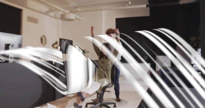 Raising arms, woman in light jacket on swivel chair, coworker reaching behind screens in office - Powered by Adobe