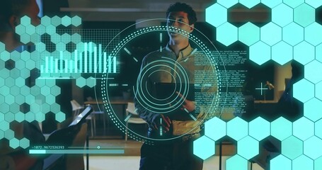 Holding tablet, man in button-up shirt presenting teal HUD in modern office, with smartphone