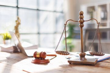Laptop law firm courtroom Law books, computer and scales of justice on table in lawyer office
