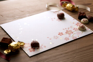 Macro shot of a handmade Japanese Valentine card with painted flowers and chocolate, soft light enhancing textures and festive mood.