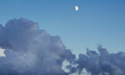 Luna di giorno nel cielo sopra le nuvole