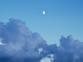Luna di giorno nel cielo sopra le nuvole