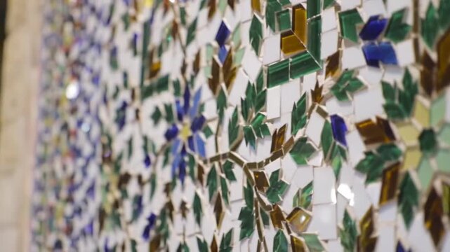 Intricate mosaic tile work featuring floral and leaf patterns in vibrant colors.