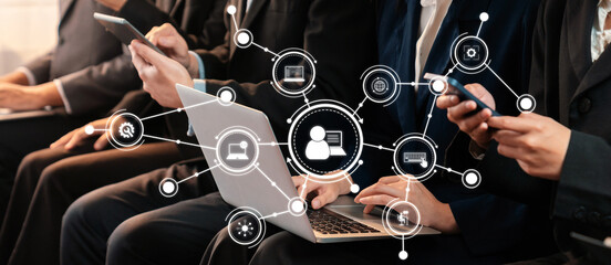 Asian job applicant in identical formal wear sitting in waiting room for job interview. Office worker or business people working in cramped room together using laptop and phone. Trailblazing Amity