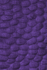 Textured purple colored wooden surface with carved oval patterns and wooden grain. Abstract texture background ideal for design, craft, or natural texture and materials themes.
