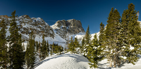 Hallett Peak Rises Over Snow Covered Forest And Emerald Lake In Rocky Mountain