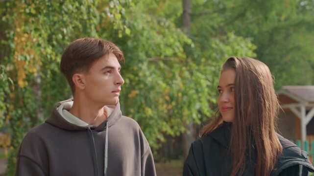 white teens laughing under birch trees, aspiring photographersturnedfriends pointing toward sky, shared secret smiles and playful banter, boy whispering teasing comment while girl blushes, layered