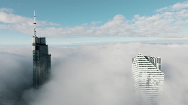 Aerial drone footage of modern skyscrapers in central Warsaw rising above low clouds and dense morning fog. The fog is so low that only tops of the buildings are visible, creating a surreal atmosphere