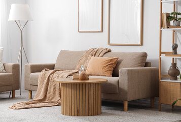 Interior of light living room with grey sofa, table and lamp