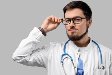 Portrait of handsome doctor in eyeglasses on light background