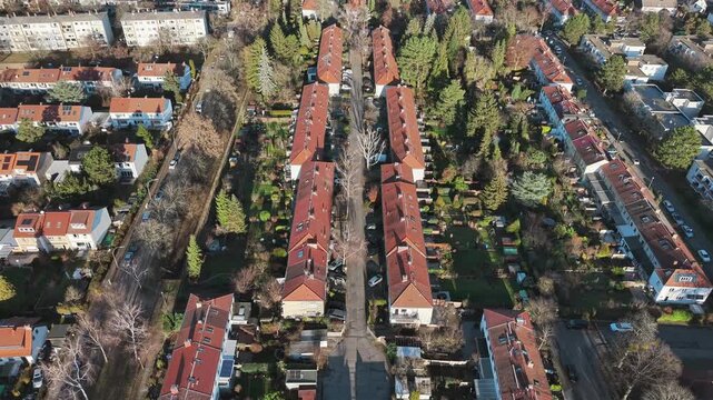 Aerial view of a residential neighborhood in Berlin Germany featuring row houses with gardens and trees on a sunny day.