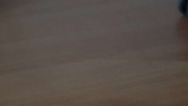 Close-up shot of rolling wheels of a rugged, hard-shell suitcase luggage on a wooden surface.