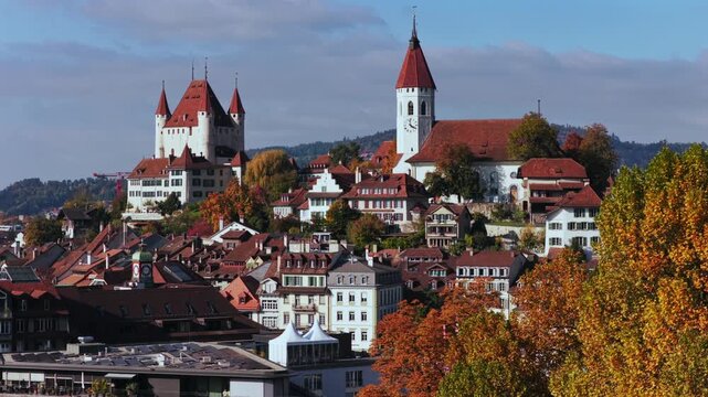 Autumn Fall Thun Castle Schloss Thun Thunersee Switzerland Schweiz aerial drone parallax blue sky clouds sunny golden yellow colorful beeches birches tree Aare River Bernese Oberland upwards motion