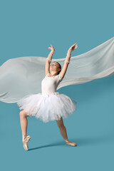 Fototapeta premium Young ballerina in tutu dancing on blue background