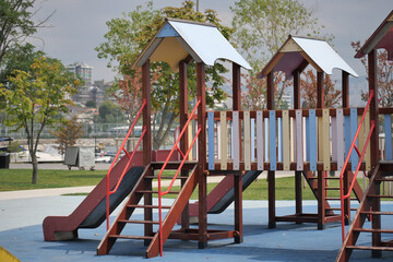Playground structure with slides and steps in a park setting