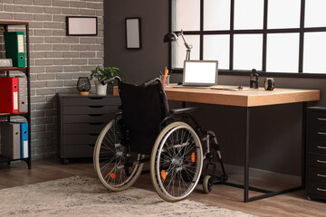 Interior of office with workplace and wheelchair