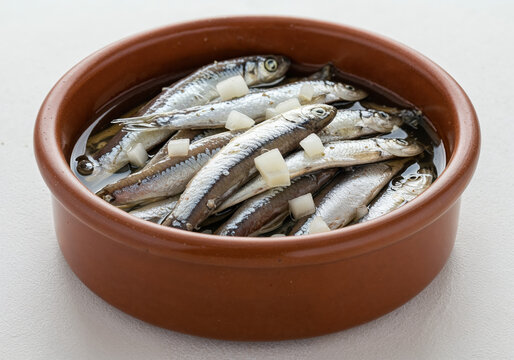 Marinated Anchovies (Boquerones) in Olive Oil with Diced Onion in a Terracotta Bowl