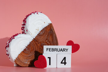 14 FEBRUARY calendar date Valentine's Day holiday Heart shaped white chocolate croissant on pink background with copy space. Puff pastry new trendy sweet dessert bakery. Creamy dough experiment 