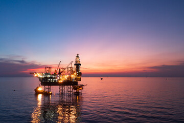 Aerial view of offshore jack up rig in a shipyard during sunset for oil and gas exploration and production.