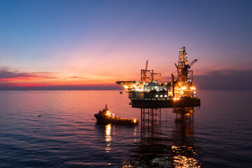 Aerial view of offshore jack up rig in a shipyard during sunset for oil and gas exploration and production.