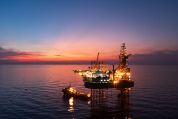 Aerial view of offshore jack up rig in a shipyard during sunset for oil and gas exploration and production.