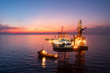 Aerial view of offshore jack up rig in a shipyard during sunset for oil and gas exploration and production.