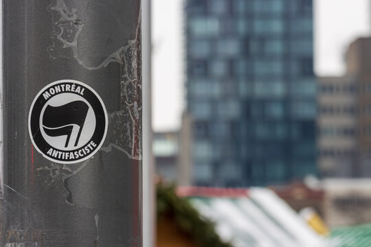 Canada, Montreal, 23 December 2025 : Sticker on urban pole with blurred cityscape in background.