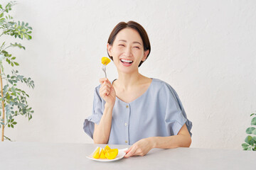 リビングで柿を食べる女性