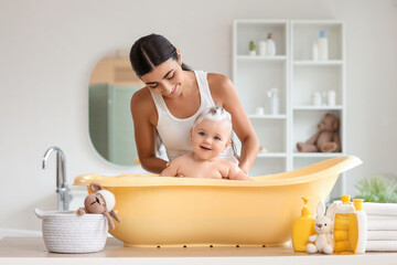 Young mother bathing her baby at home