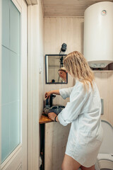 woman preparing natural stone sink on wooden countertop in cozy bathroom interior at home calm morning routine indoor lifestyle concept of wellness spa interior design home living