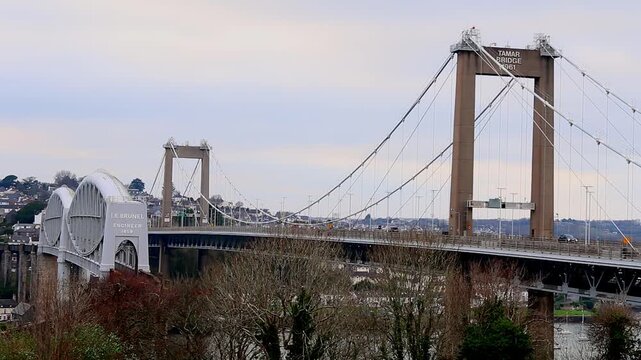 Rail bridge designed by Isambard Kingdom Brunel and cars passing over the road bridge spanning thee river Tamar in Devon, UK. iboth going from Devon into Cornwall