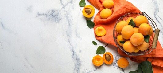 Basket of ripe apricots on light background with space for text