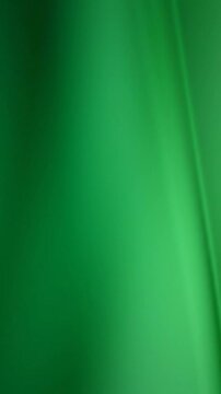 A smooth, abstract green background with varying shades and a subtle diagonal crease