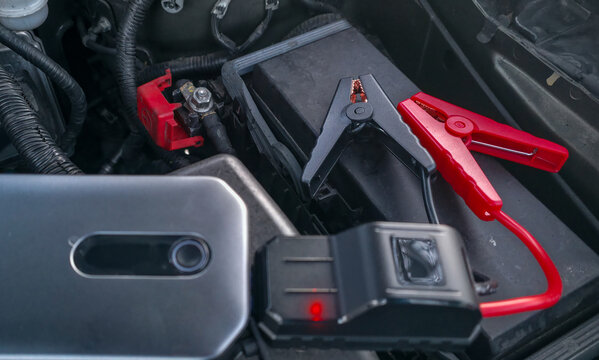 Portable jump starter for a car engine. Assistance for the driver when the car battery is dead.