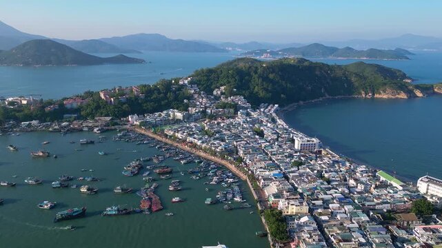 Cheung Chau, Hongkong: forward aerial drone footage of Cheung Chau, a fisherman village in a typical Hong Kong outlying island, with Lantau mountain in the background