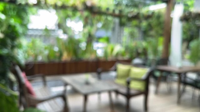 Exterior of cafe, coffe shop or restaurant with plants, tables and chairs. empty. green leaves, leaf. nature. eco, ecology. environment. plant. cozy. outdoor. indoor. interior. blur, blurry, blurred. 